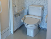 手すりや温水洗浄暖房便座を備えたトイレ